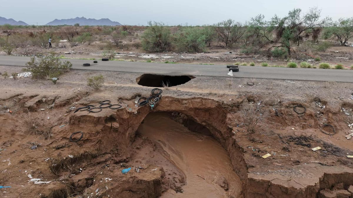 Policía Municipal, Bomberos y Protección Civil, mantienen operativo de seguridad en la Calle O Sur, a 300 metros de la Carretera 100 que conduce a la Costa de Hermosillo y Bahía de Kino, ya que ayer el agua pasó por debajo y encima de la carretera formándose un hoyo y con riesgo de colapso. Por tal motivo está bloqueado el paso hacia el ejido “San Luis”. FOTO: JULIÁN ORTEGA