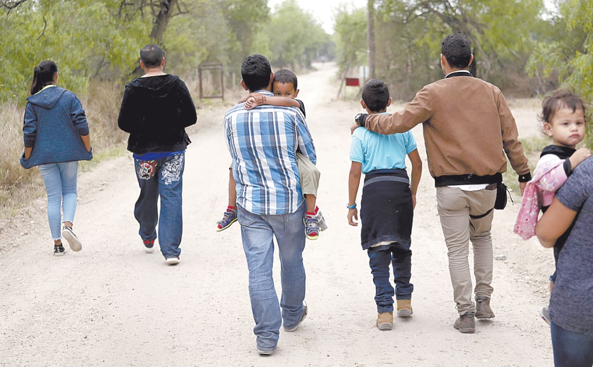 En esta fotografía de archivo del 14 de marzo de este año un grupo de familias migrantes recorre un camino poco antes de ser detenidas por la Patrulla Fronteriza cerca de McAllen, Texas.