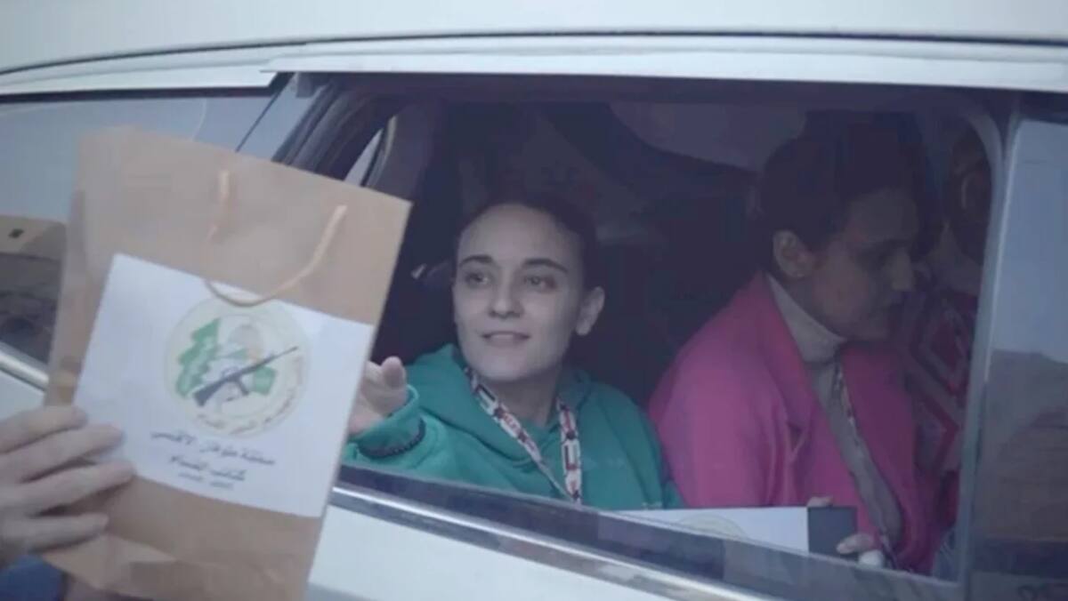 Militar le entregó una bolsa a Emily Damari mientras la trasladaban a la Cruz Roja en Gaza el domingo. / Hamás.