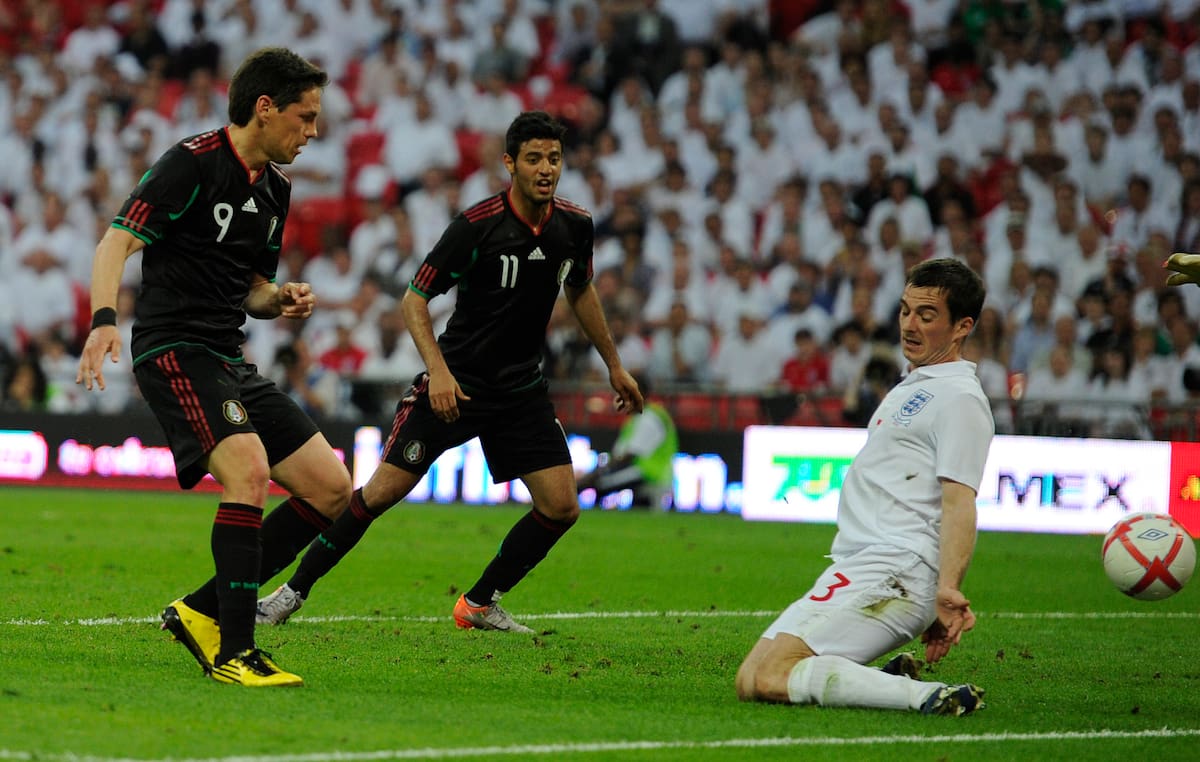 Mexico's Guillermo Franco, left, shoots and scores a goal as England's Leighton Baines reacts, right, during their international soccer friendly match at Wembley stadium in London, Monday, May 24, 2010. Both England and Mexico have qualified for the World Cup in South Africa 2010, and are playing a series of friendlies in preparation for the competition. (AP Photo/Tom Hevezi)