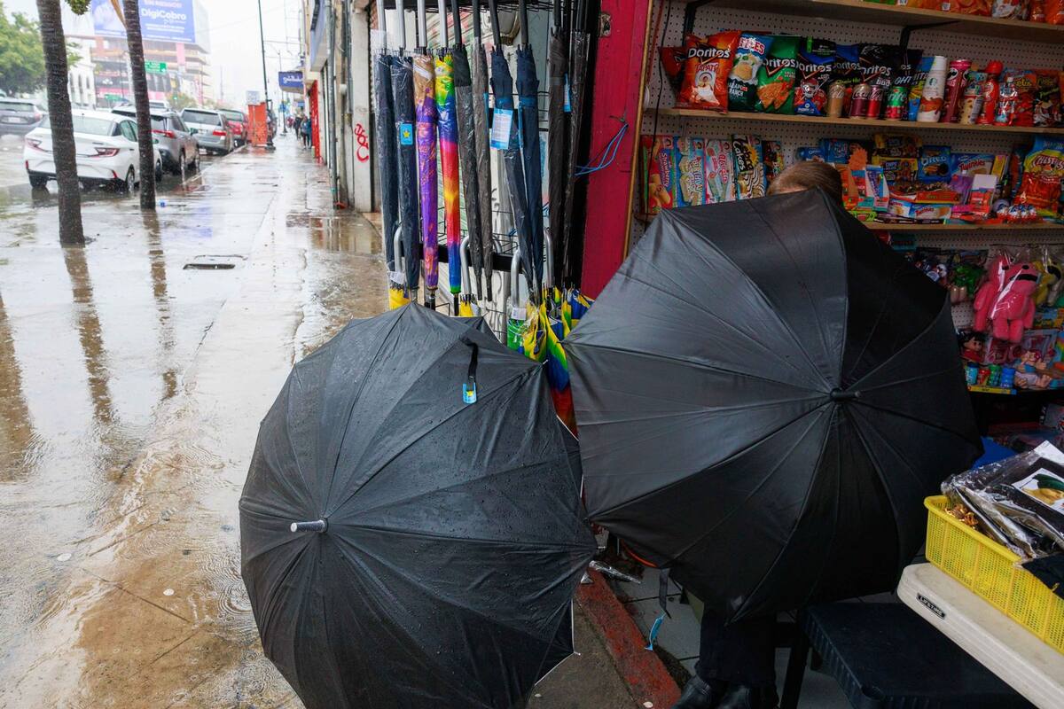 Los locatarios se protegieron de la lluvia.