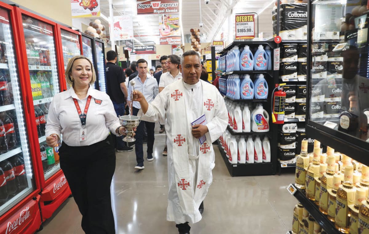 El sacerdote Alfonso Ramírez bendice las instalaciones del Super Ley Express en el Poblado Miguel Alemán.