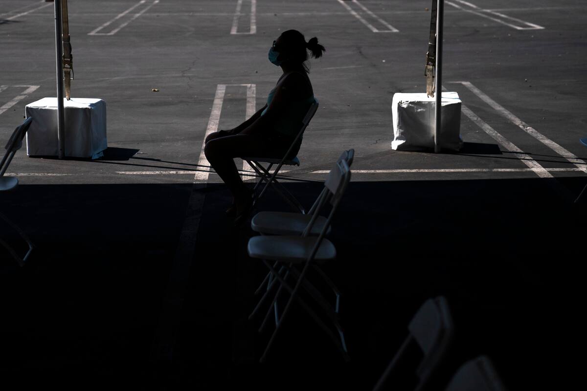 ARCHIVO - En esta imagen de archivo del 28 de agosto de 2021, una mujer en una zona de espera tras recibir una vacuna contra el COVID-19 en una clínica instalada en el estacionamiento de CalOptima en Orange, California. (AP Foto/Jae C. Hong, Archivo)