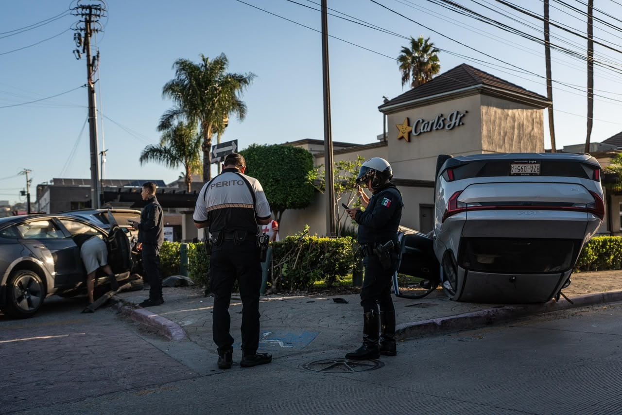 Un Kia volcó tras chocar contra un Tesla en el bulevar Agua Caliente de Tijuana; el Tesla impactó otros dos vehículos estacionados. Foto: Border Zoom