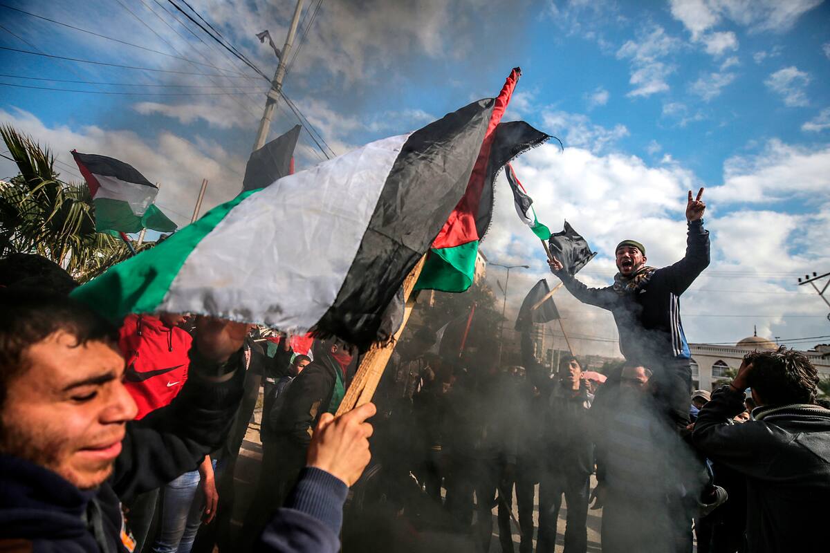 -FOTODELDÍA- EPA3962. GAZA (GAZA Y CISJORDANIA), 28/01/2020.- Varias personas gritan consignas y portan banderas nacionales durante una protesta contra la iniciativa que el presidente estadounidense, Doandl Trump, ha ofrecido para el proceso de paz en Oriente Medio, este martes en Gaza. El Ejército de Israel ha aumentado su presencia militar en el Valle del Jordán, en Cisjordania ocupada, ante posible protestas por la publicación de dicho plan de paz. EFE/ Mohammed Saber