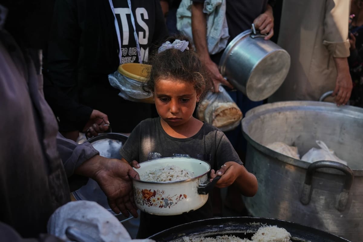 Palestinos reciben alimentos donados en una cocina comunitaria.
Foto: Agencia AP/Abdel Kareem Hana