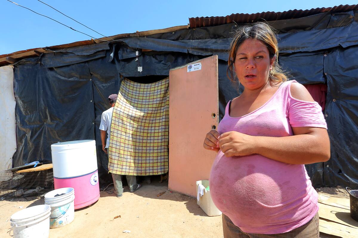 A 48 grados y bajo techo de lámina, mujer embarazada aguanta el calor
