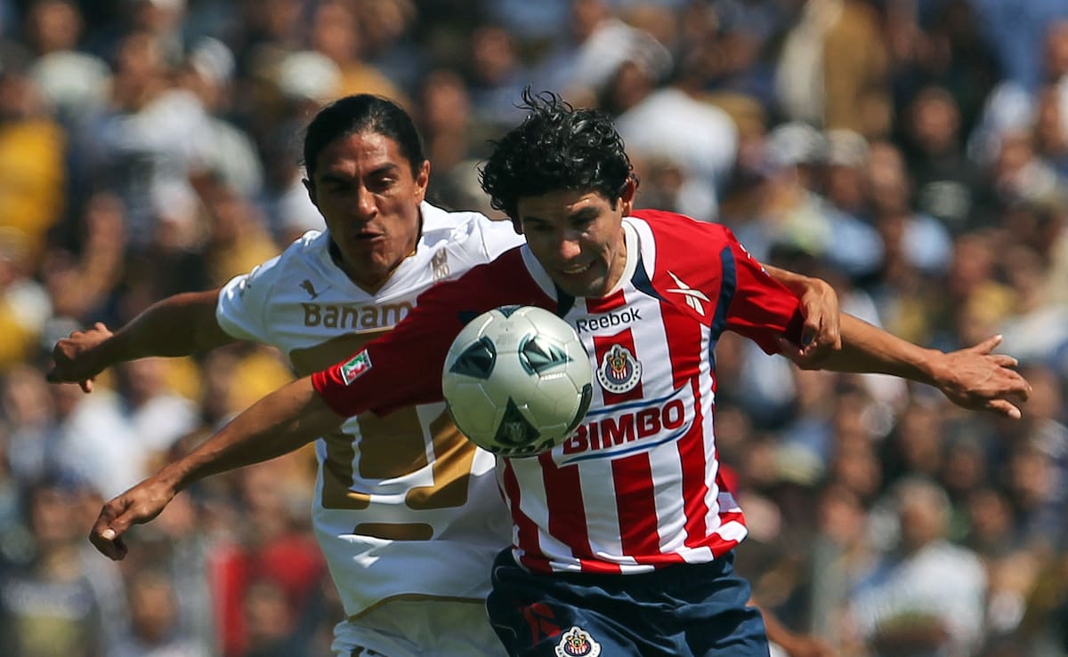 Pumas' Francisco Palencia, back, and Chivas' Jonny Magallon fight for the ball during a Mexican soccer league match in Mexico City, Sunday Feb. 13, 2011. (AP Photo/Eduardo Verdugo)
