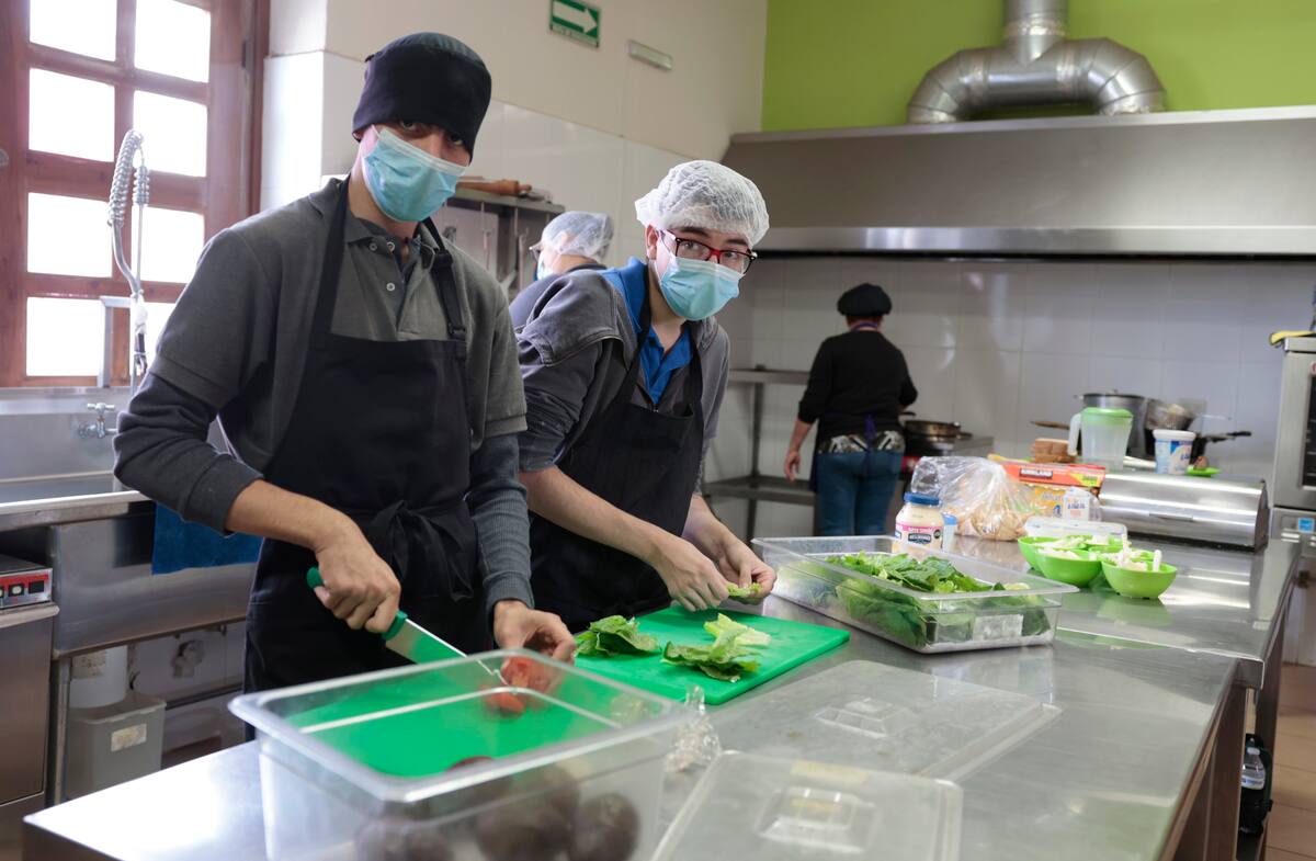 Los jóvenes Diego Navarro y Jesús Andrés Manríquez Soto ayudan en el área de la cocina de Buena Vibra Café. FOTO: TEODORO BORBÓN