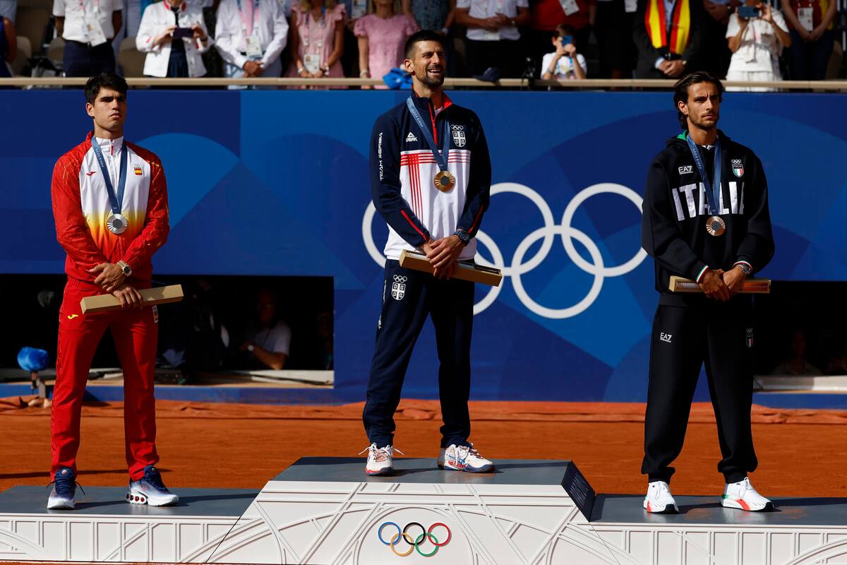 Los tenistas, el serbio Novak Djokovic (c-oro), el español Carlos Alcaraz (i-plata) y el italiano Lorenzo Musetti (d-bronce), posan en el podio tras la final individual masculina de tenis de los Juegos Olímpicos de París 2024 este domingo, en la capital gala. | Crédito: EFE/Juanjo Martín