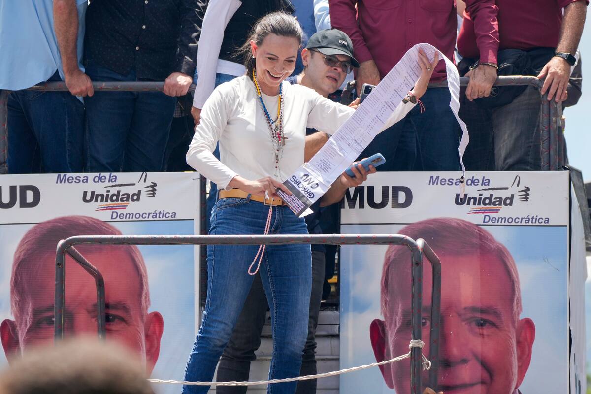 La líder opositora María Corina Machado sostiene actas de recuento de votos durante una manifestación para protestar por los resultados oficiales que declararon al presidente Nicolás Maduro como ganador de las elecciones presidenciales de julio, en Caracas, Venezuela, el sábado 17 de agosto de 2024. (Foto AP/Ariana Cubillos)