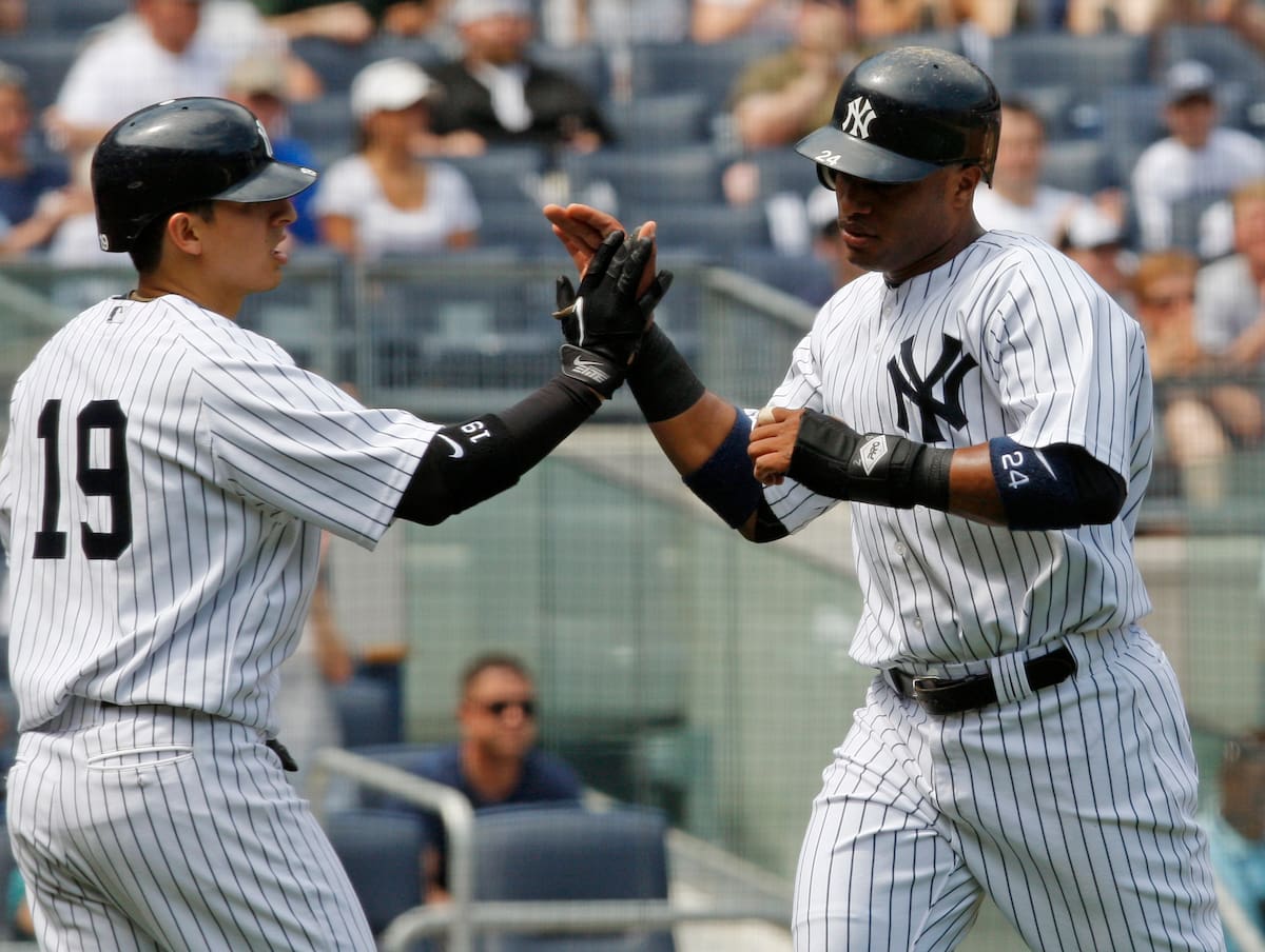 Ramiro Peña felicita a su compañero Robinson Canó de los Yankees de Nueva York en 2010. (AP Photo/Kathy Willens)