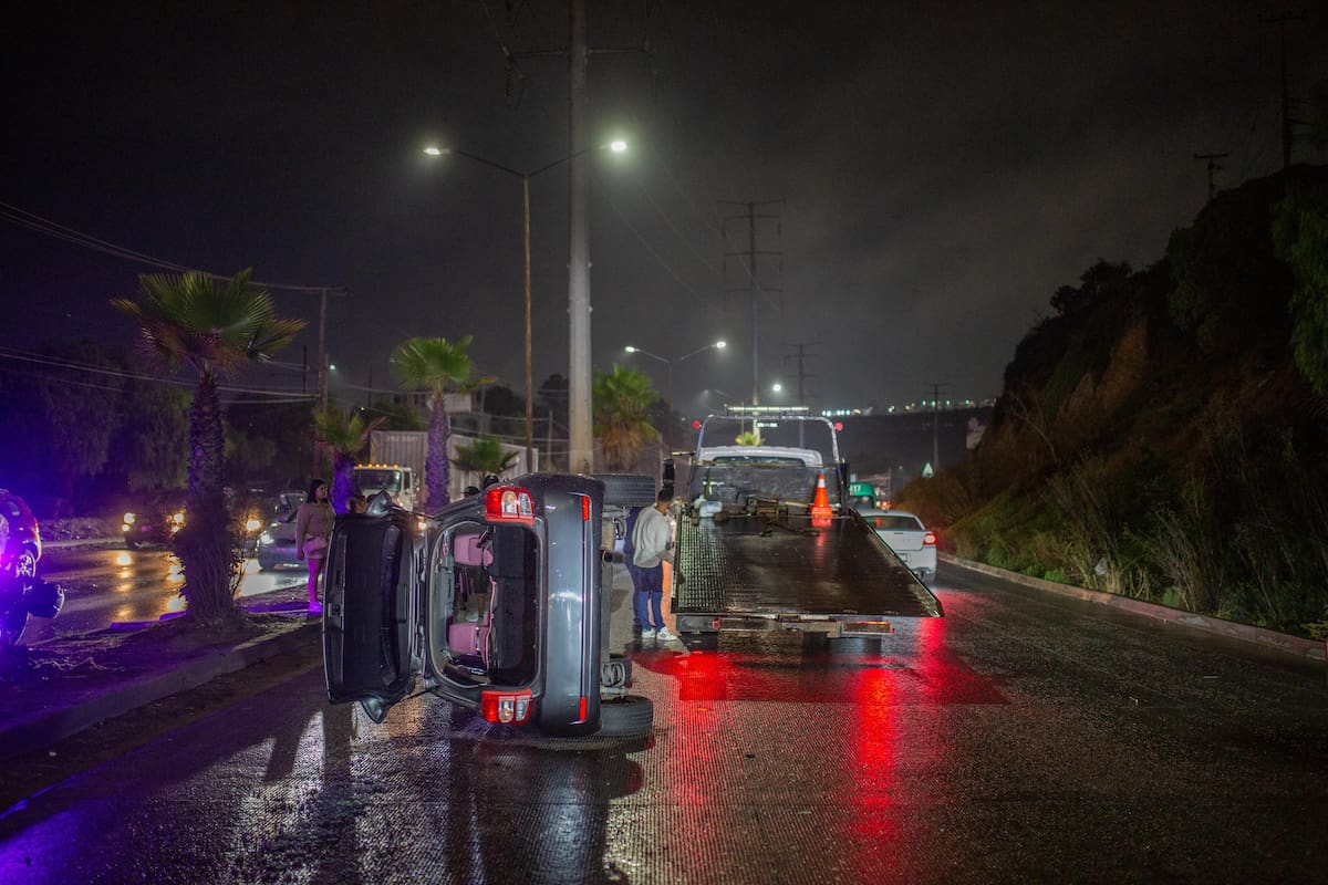 Uno de los conductores perdió el control debido al pavimento mojado, lo que provocó la volcadura de su vehículo. Foto: Border Zoom