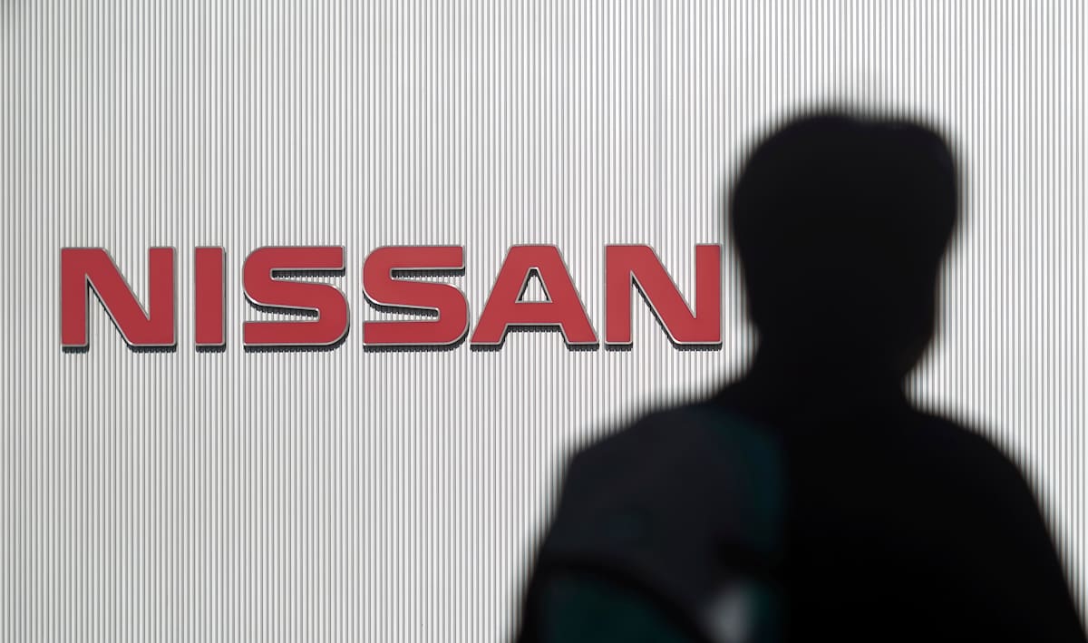A man walks past the logo of Nissan Motor Co. at Nissan Motor Co. Global Headquarters in Yokohama near Tokyo Wednesday, Nov. 21, 2018. France's Renault says it has decided to keep its CEO Carlos Ghosn on despite his arrest in Japan on allegations that he misused assets of partner Nissan Motor Co. and misreported his income. Renault's board of directors announced late Tuesday that the No. 2 at the company, Chief Operating Officer Thierry Bollore, would temporarily fill in for Ghosn. (AP Photo/Eugene Hoshiko)