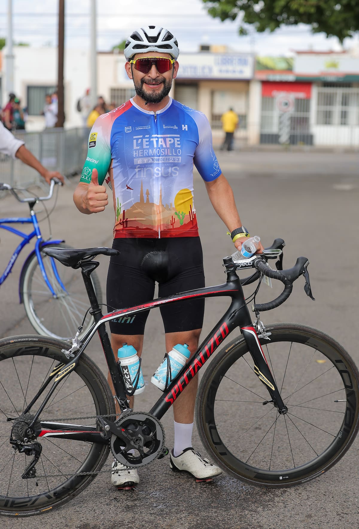 Con una sonrisa y el pulgar en alto, Israel González Bastida celebra su triunfo en L’Étape Hermosillo, una victoria que dedicó a su madre, esposa e hijos, quienes lo apoyaron para competir en Sonora.