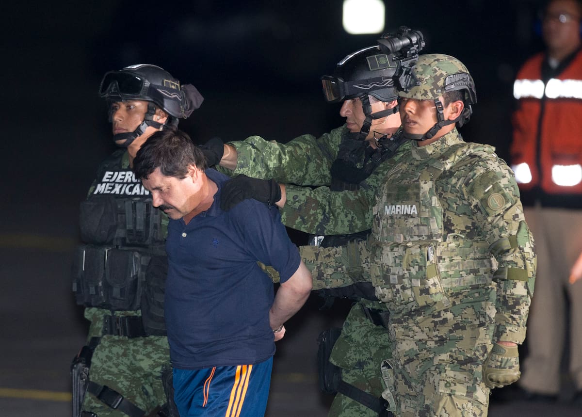 Joaquin "El Chapo" Guzman is escorted to a helicopter in handcuffs by Mexican soldiers and marines at a federal hangar in Mexico City, Mexico, Friday, Jan. 8, 2016. Mexican President Enrique Pena Nieto announced that Guzman had been recaptured six months after escaping from a maximum security prison. (AP Photo/Eduardo Verdugo)
