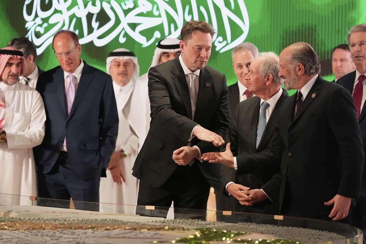 Elon Musk (centro) estrecha la mano del secretario de Comercio, Howard Lutnick (derecha), mientras observan la maqueta de una ciudad en construcción, el martes 13 de mayo de 2025, en Riad, Arabia Saudita. | Crédito: AP/Alex Brandon