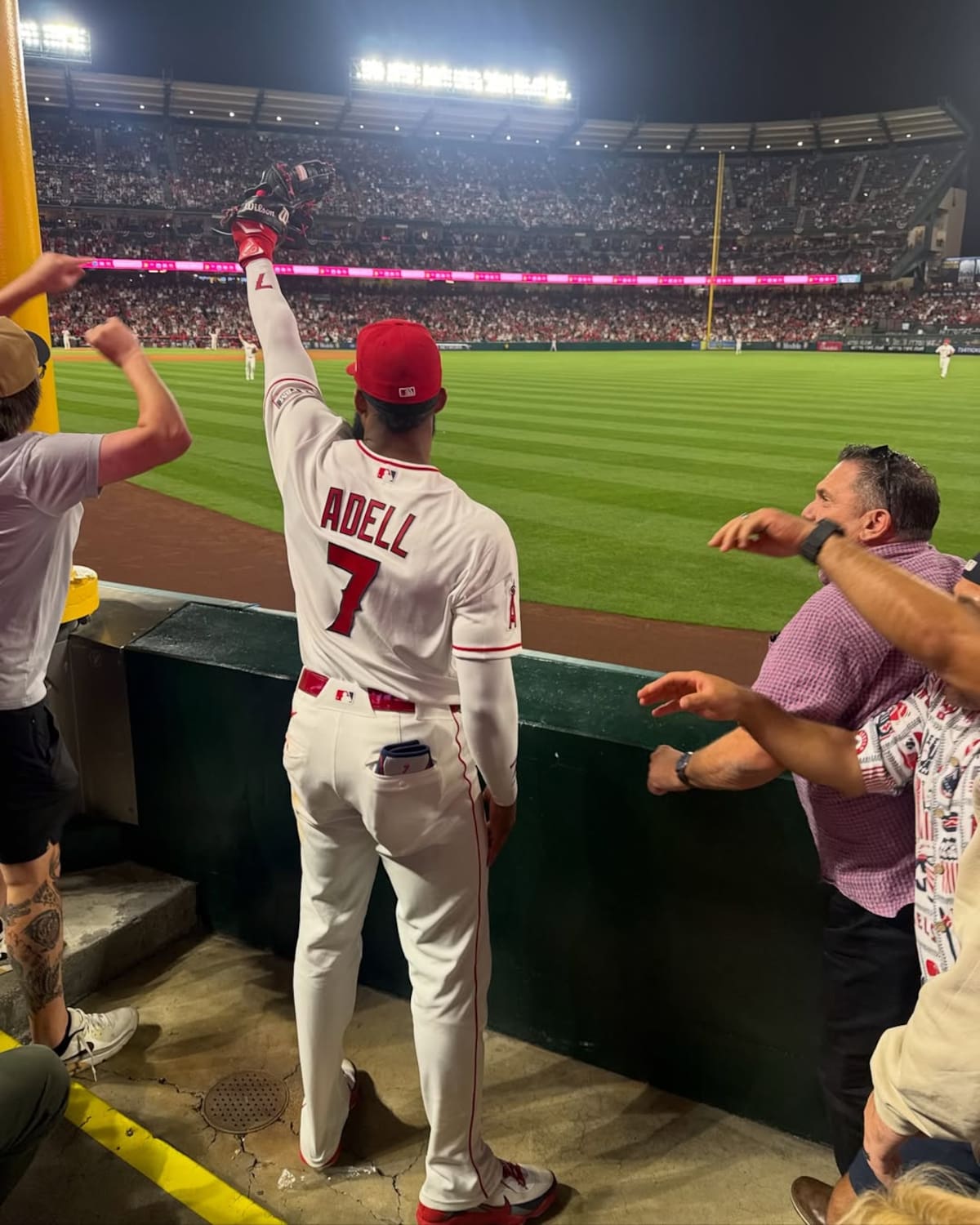Jo Adell levanta su guante con la pelota que atrapó detrás de la barda del jardín derecho; la foto fue capturada por la aficionada Kayleigh Kraus. (Foto: @angels / @kay_kraus)