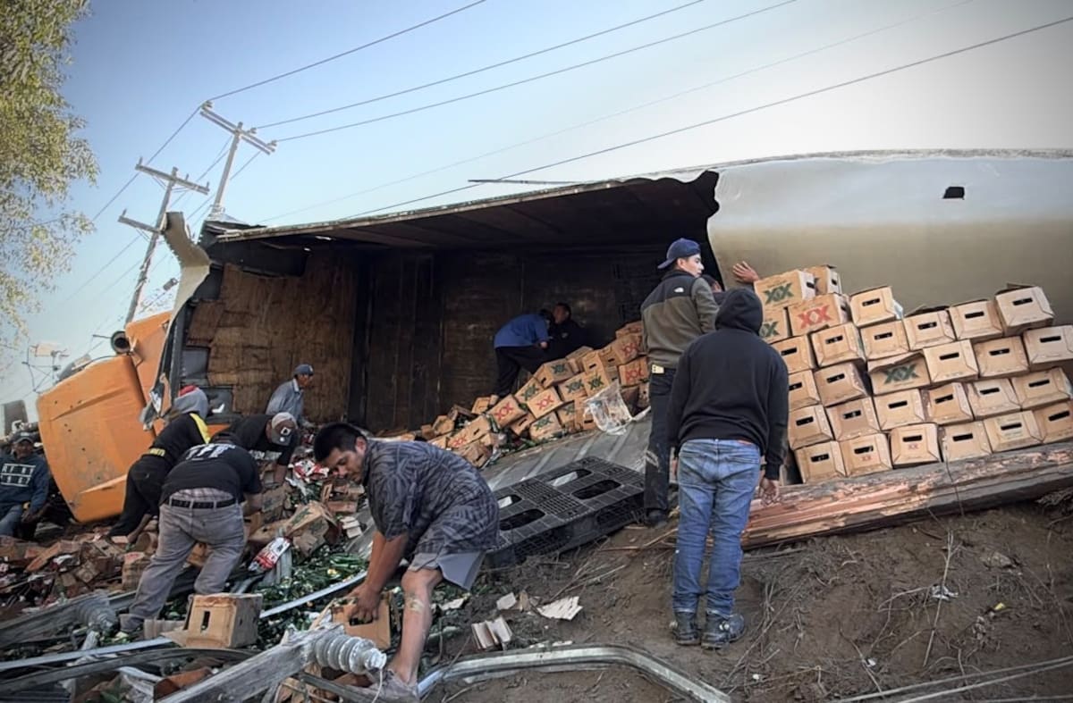Personas cargaron cerveza en baldes y tinas tras la volcadura en Granjas Buenos Aires. Foto: Border Zoom