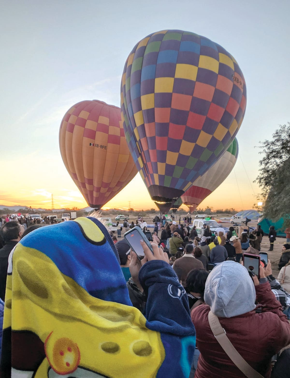 Gente en Econatura capta con sus celulares el momento en que los globos están listos para volar. FOTO: JULIÁN ORTEGA