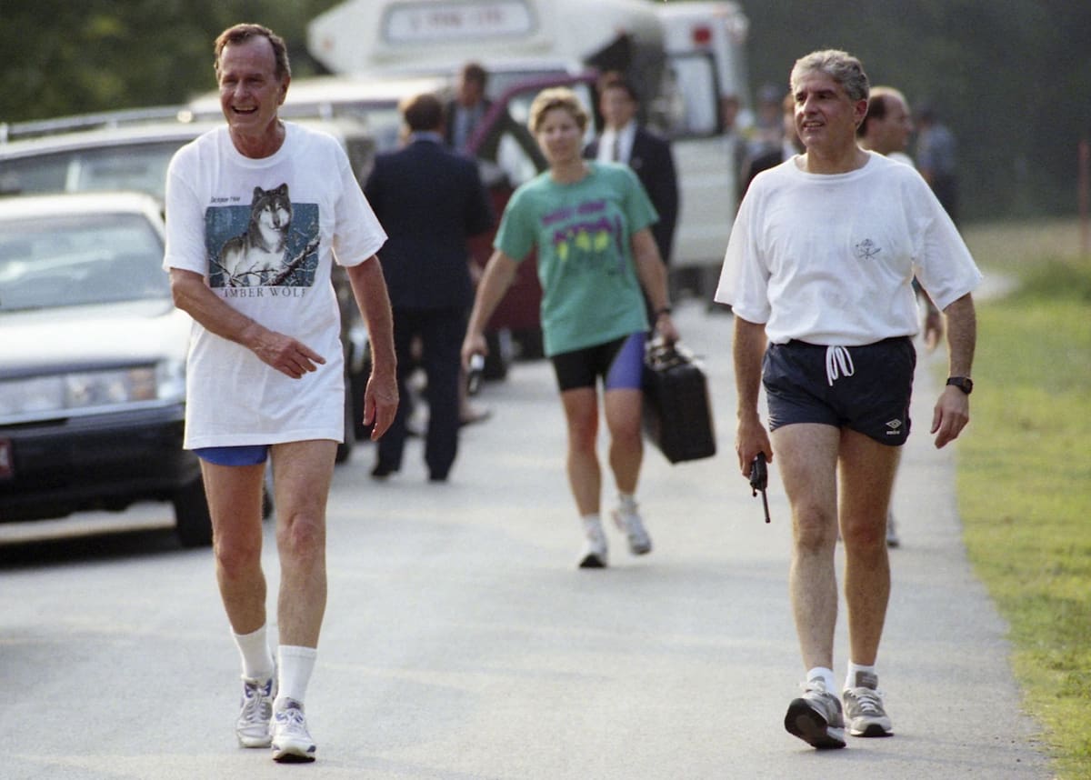 En esta foto obtenida por el Archivo de Seguridad Nacional de la Biblioteca Presidencial George H. W. Bush, la mayor Michelle D. Johnson, asistente de la Fuerza Aérea en la Casa Blanca, lleva el Maletín Nuclear Mochila de Emergencia Presidencial detrás del presidente George H. W. Bush en Branson, Misuri, el 21 de agosto de 1992. | Crédito: Biblioteca Presidencial George H. W. Bush/Archivo de Seguridad Nacional - nsarchive.gwu.edu a través de AP