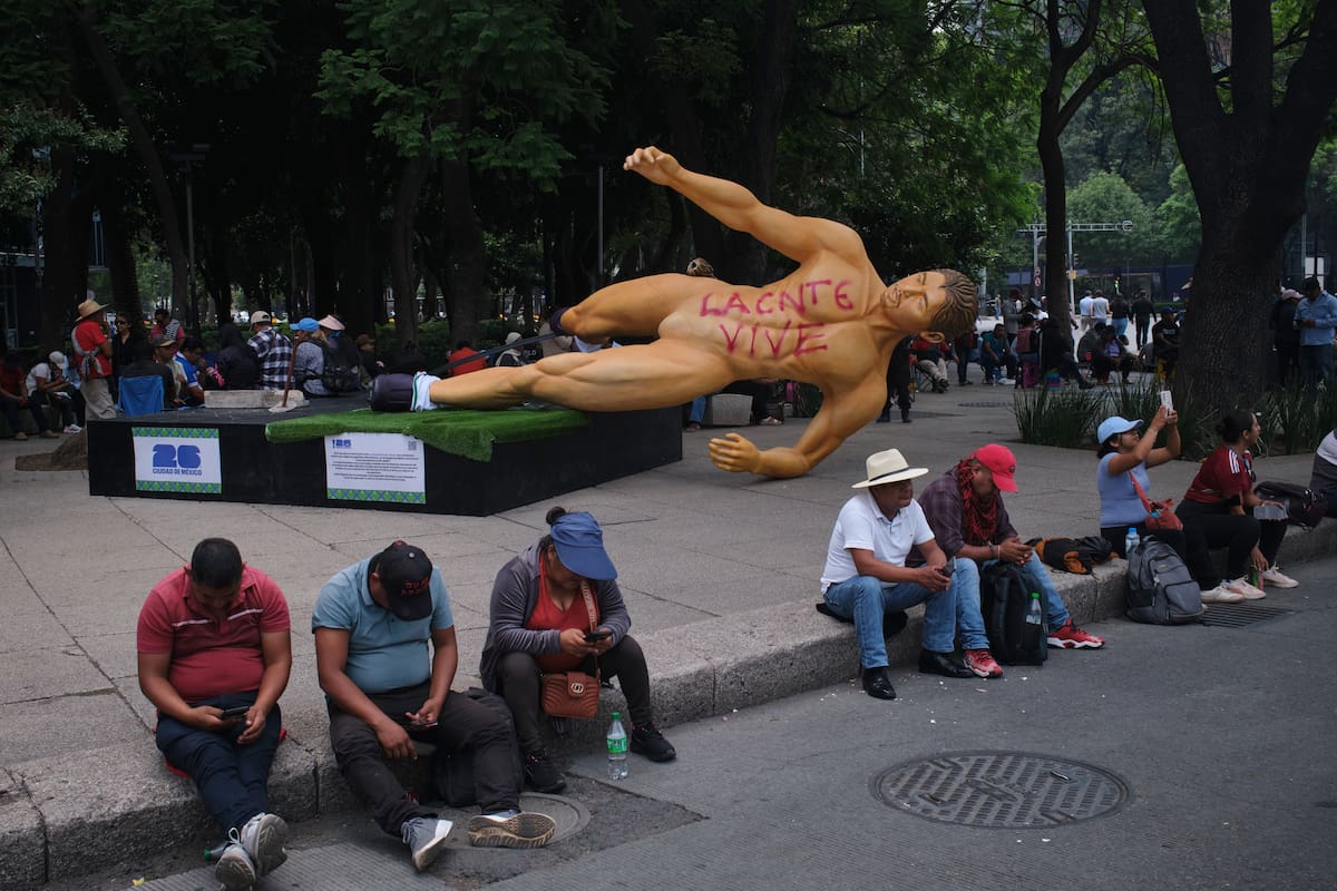 Una estatua del Mundial, con un grafiti que dice en español "La CNTE vive", en referencia a la Coordinadora Nacional de Trabajadores de la Educación, yace de lado durante una protesta de maestros por mejores salarios en Ciudad de México, el martes 2 de junio de 2026. (Foto AP/Jon Orbach)