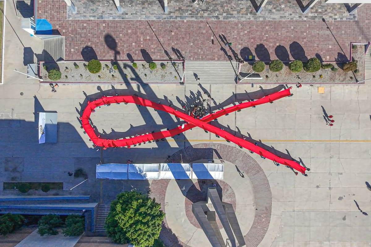 Autoridades y el colectivo Comunidad de Arcoiris BC formaron un mega lazo rojo l Foto: Andrés O. Farrera