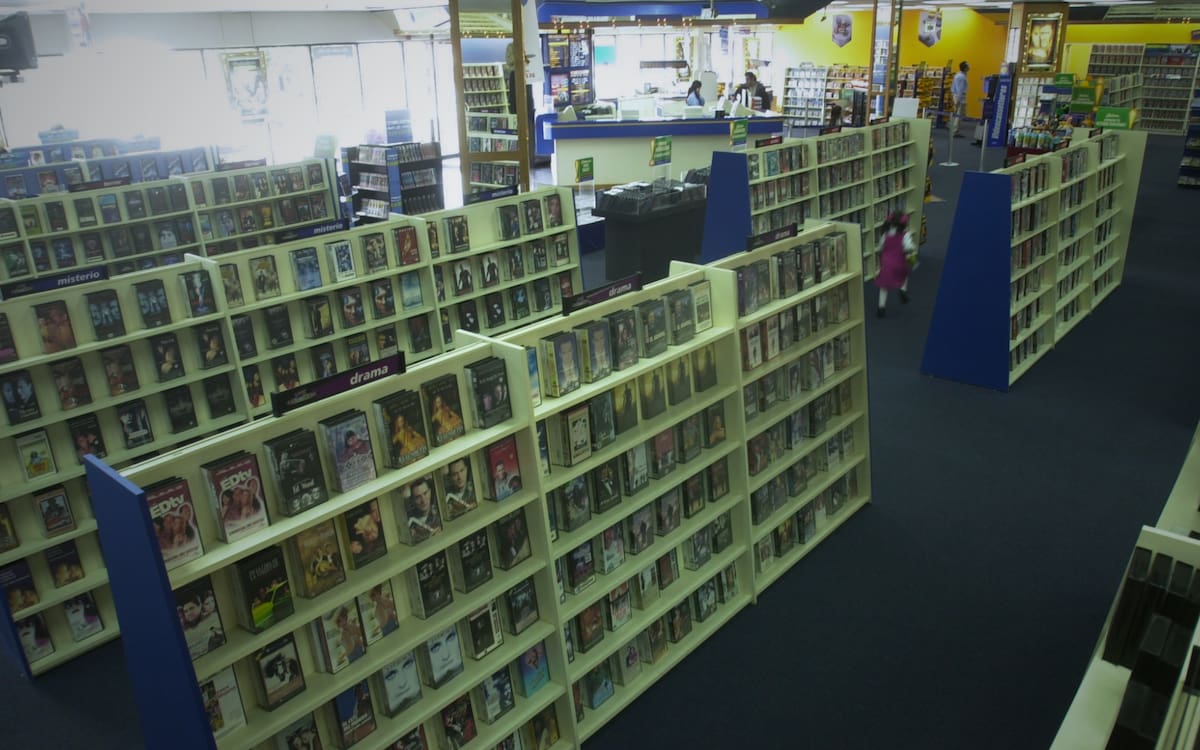 Cruzar la puerta automática significaba sumergirse en un universo de expectativas: hojear las portadas de cartón de los VHS y, posteriormente, de los DVD, buscar los estrenos más codiciados —con la esperanza de que hubiera al menos una copia disponible en la sección de "Nuevos Lanzamientos"— y decidir si se acompañaría la función con dulces o palomitas de la marca. Foto: Archivo GH