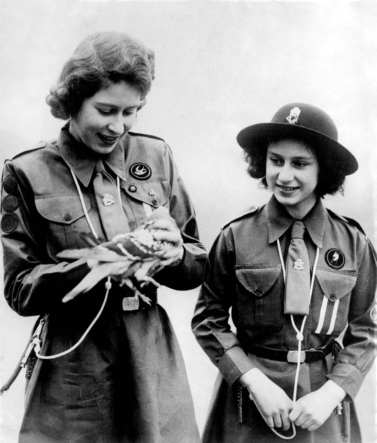 Picture taken on 1943 showing Princess Elizabeth, the futur Queen Elizabeth II, with her sister Princess Margaret admiring a pigeon before its departure with their message. (Photo by - / PLANET NEWS / AFP) (Photo credit should read -/AFP via Getty Images)