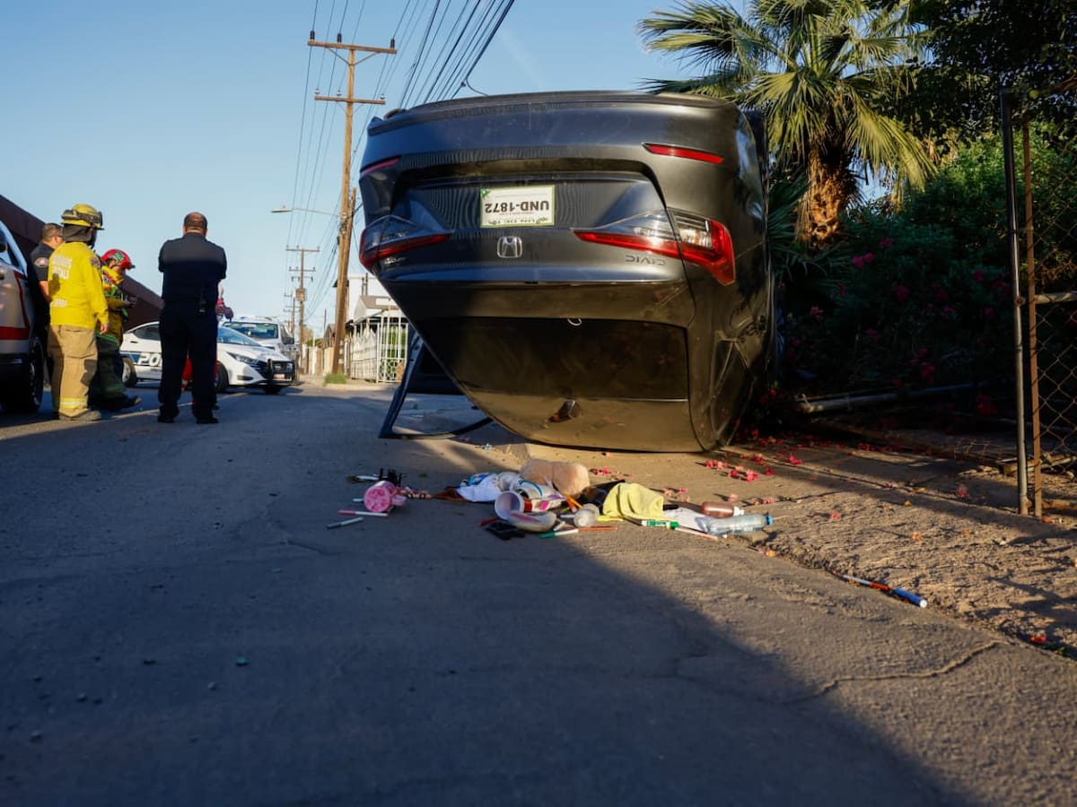 La unidad terminó volcada y derribó el cerco de un domicilio; la mujer fue atendida por paramédicos. Foto: Juan J. Morales