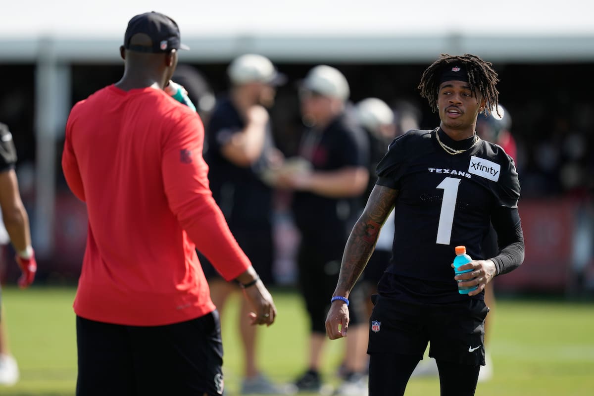 El wide receiver Tank Dell (1), de los Texans de Houston, saluda al head coach DeMeco Ryans durante una práctica del equipo de la NFL en el campamento de entrenamiento, el viernes 7 de agosto de 2026, en Houston. (AP Foto/Ashley Landis)