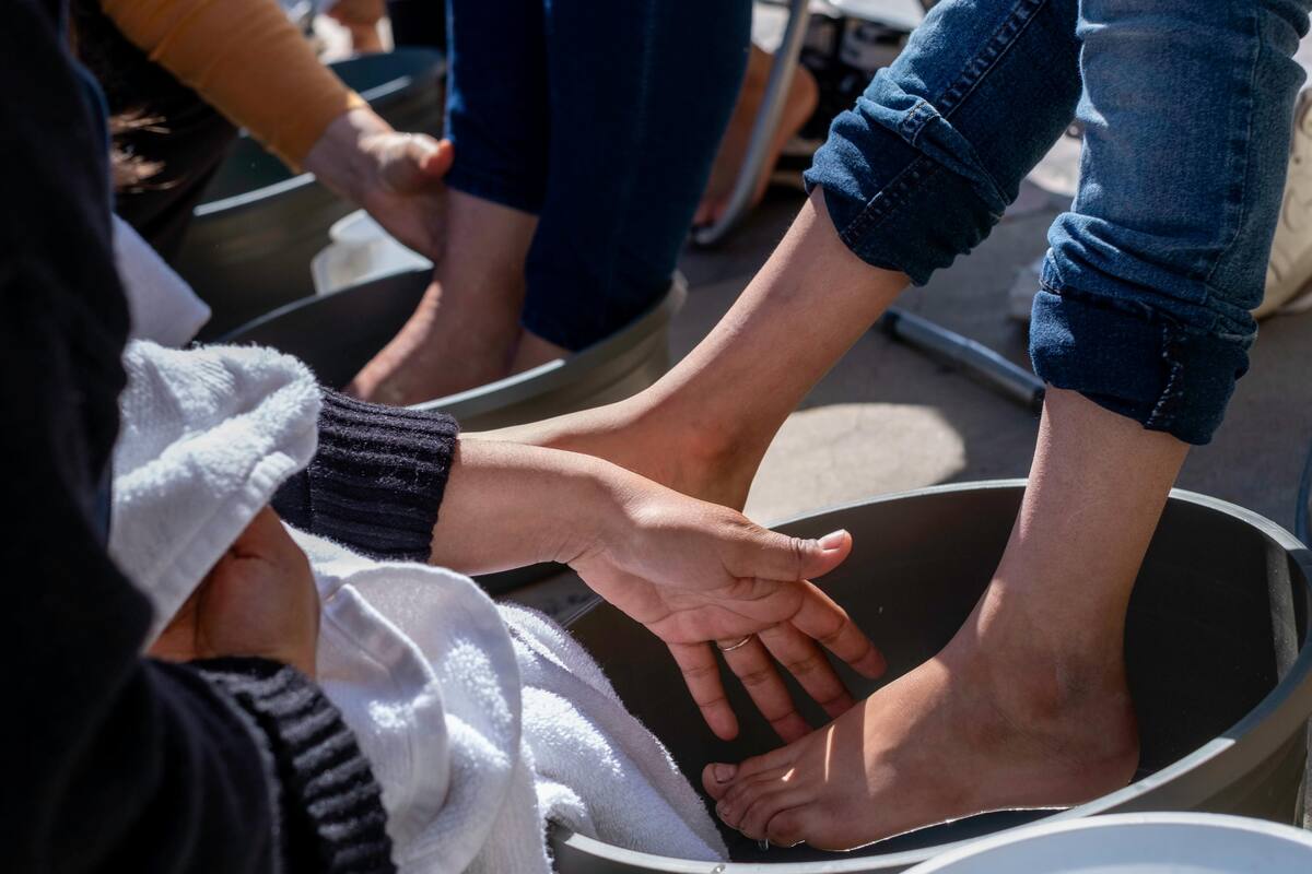 Activistas lavan pies de migrantes en memoria de Jesús