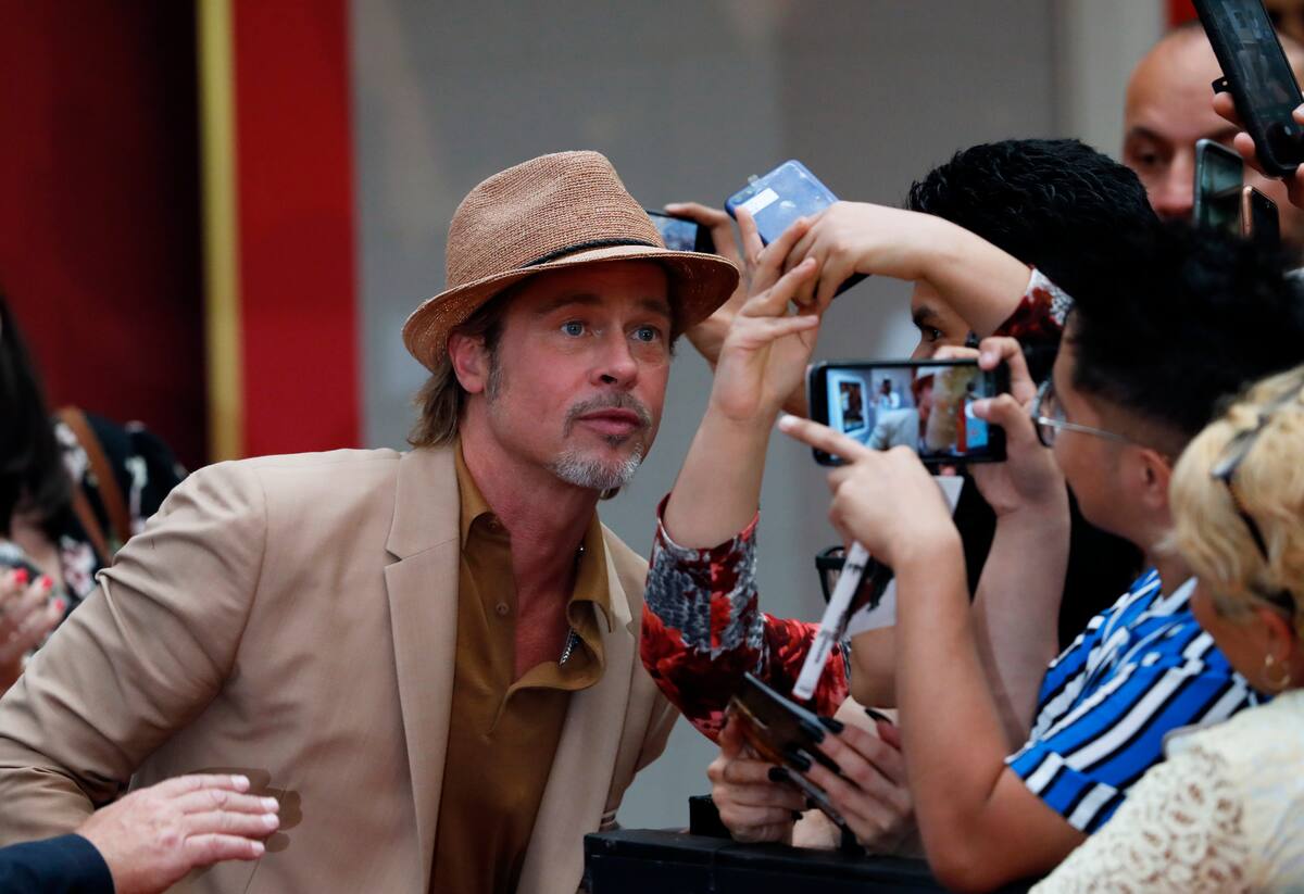 Brad Pitt posa para fans en la alfombra roja de la película "Once Upon a Time... In Hollywood" en la Ciudad de México el 12 de agosto de 2019. La cinta se estrena el 23 de agosto en México. (Foto AP/Marco Ugarte)