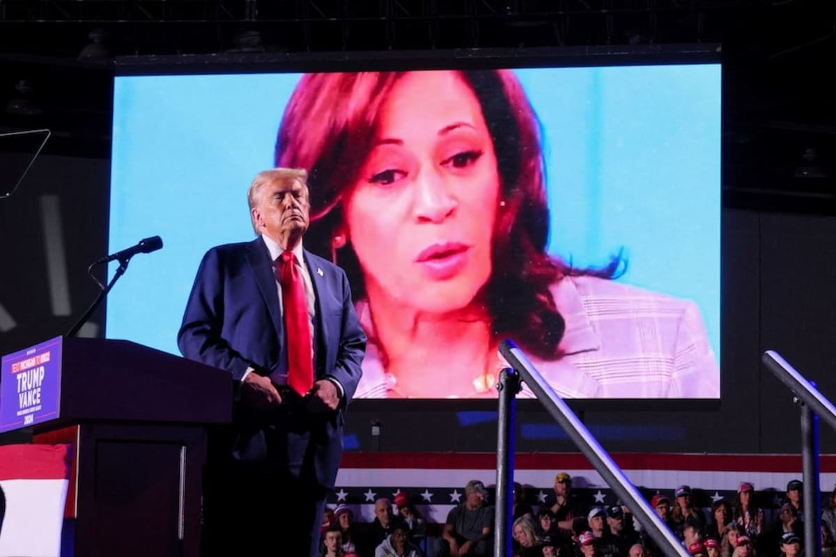 El candidato presidencial republicano y ex presidente de EE. UU., Donald Trump, observa cómo aparece el rostro de la candidata presidencial demócrata y vicepresidenta de Estados Unidos, Kamala Harris, mientras un video se reproduce en una pantalla, durante un mitin en Huntington Place en Detroit, Michigan, EU, el 18 de octubre de 2024. | Crédito: REUTERS