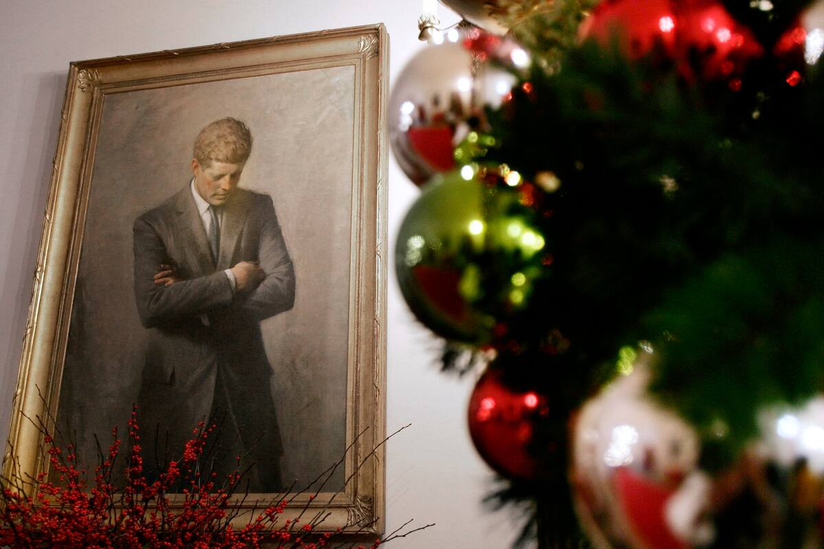 ARCHIVO - La foto de archivo del 30 de noviembre de 2006 muestra el retrato del expresidente John F. Kennedy, enmarcado por decoraciones navideñas, en la Casa Blanca en Washington. Exhiben una carta del presidente John F. Kennedy a una niña temerosa por la seguridad de Santa Claus. La Biblioteca y Museo JFK en Boston exhibe la carta y otros artefactos con tema navideño en su vestíbulo (AP Foto/Ron Edmonds, File)
