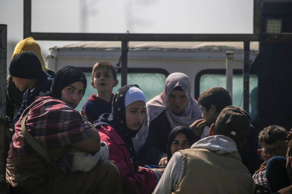 Palestinos viajan en la parte trasera de un camión a lo largo de la carretera Al Rashid, al sur de la ciudad de Gaza. EFE/EPA/