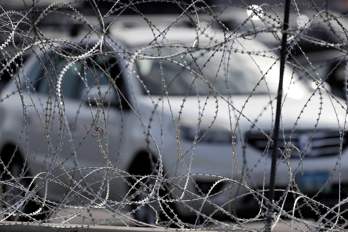 Cars line up to cross into the United States from Tijuana, Mexico, seen through barriers topped with concertina wire at the San Ysidro port of entry Monday, Nov. 19, 2018, in San Diego. The United States closed off northbound traffic for several hours at the busiest border crossing with Mexico to install new security barriers on Monday, a day after hundreds of Tijuana residents protested against the presence of thousands of Central American migrants. (AP Photo/Gregory Bull)