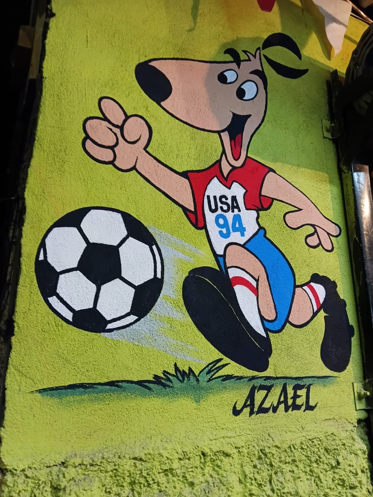 Striker, mascota de USA 94 decora la entrada de una cenaduría enseguida del mural mundialista. (Foto: Patrizio Caro)