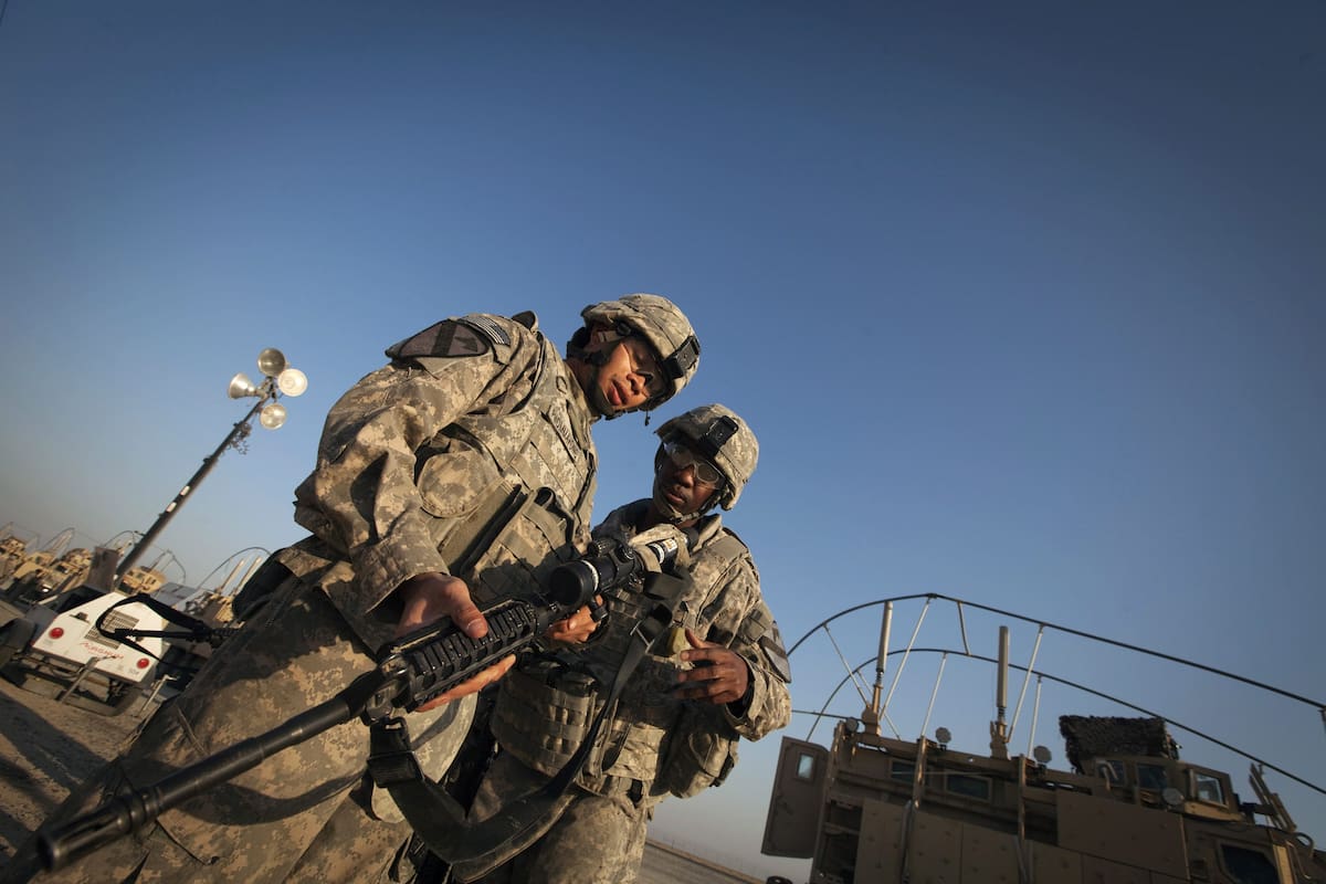 REU38 KUWAIT 18/12/2011.- Soldados de la 3ª Brigada, 1ª División de Caballería, del ejército estadounidense descargan sus armas tras cruzar la frontera kuwaití junto al último convoy de tropas norteamericanas que abandonó Irak.