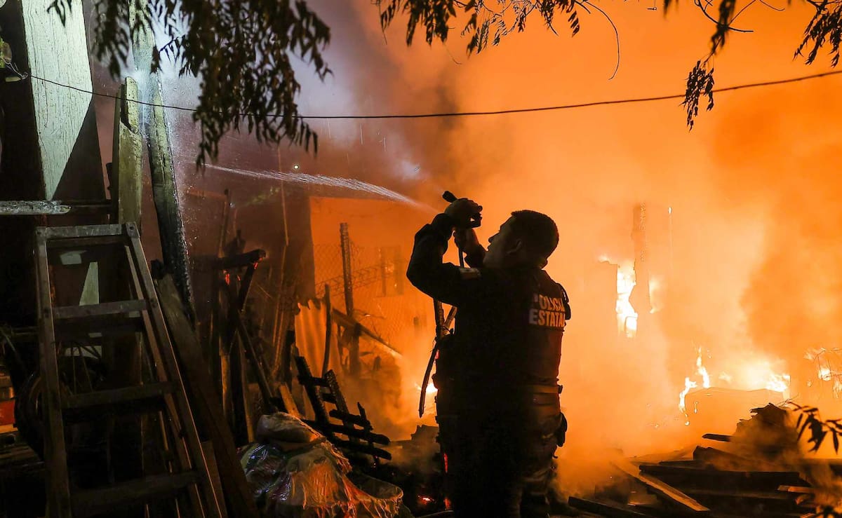 El agente de la Policía Estatal, Martín Corral Zepeda, utiliza una manguera para contener las llamas y evitar que el fuego se propagara a otras viviendas. / Imagen por Eleazar Escobar.
