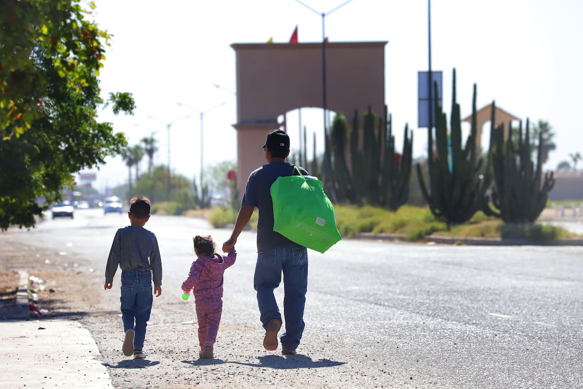 Residentes de la colonia Natura caminan más de 1 kilómetro para poder tomar el transporte urbano o taxi colectivo; en la gráfica el señor Roberto Rojo y sus hijos.
