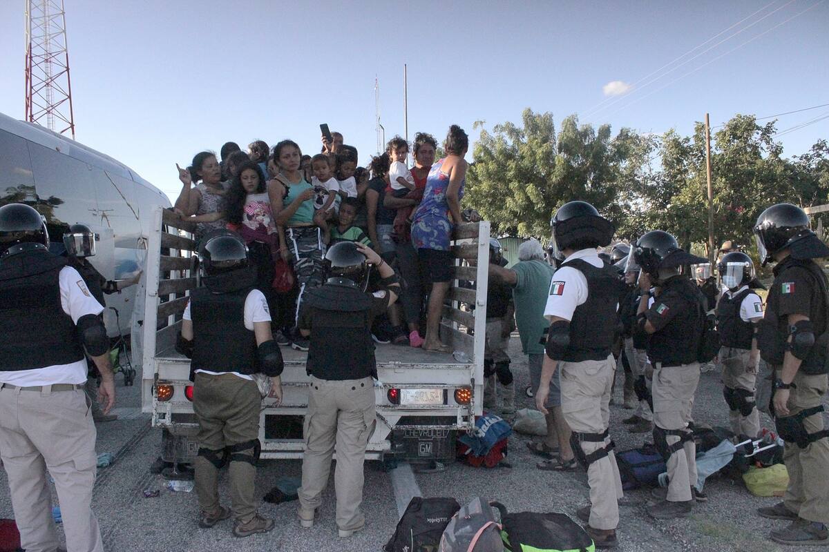 MEX6372. TONALA (MÉXICO), 05/11/2021.- Personal de la Guardia Nacional detiene el avance de migrantes quienes avanzan en una caravana rumbo a la Ciudad de México, hoy, en el municipio de Tonala, estado de Chiapas (México). Agentes de la Guardia Nacional y del Instituto Nacional de Migración (INM) desplegaron un operativo para detener a la caravana de migrantes que partió este viernes de la ciudad de Tonalá, en el estado de Chiapas, sur de México, en dos camionetas de carga. EFE/ Juan Manuel Blanco