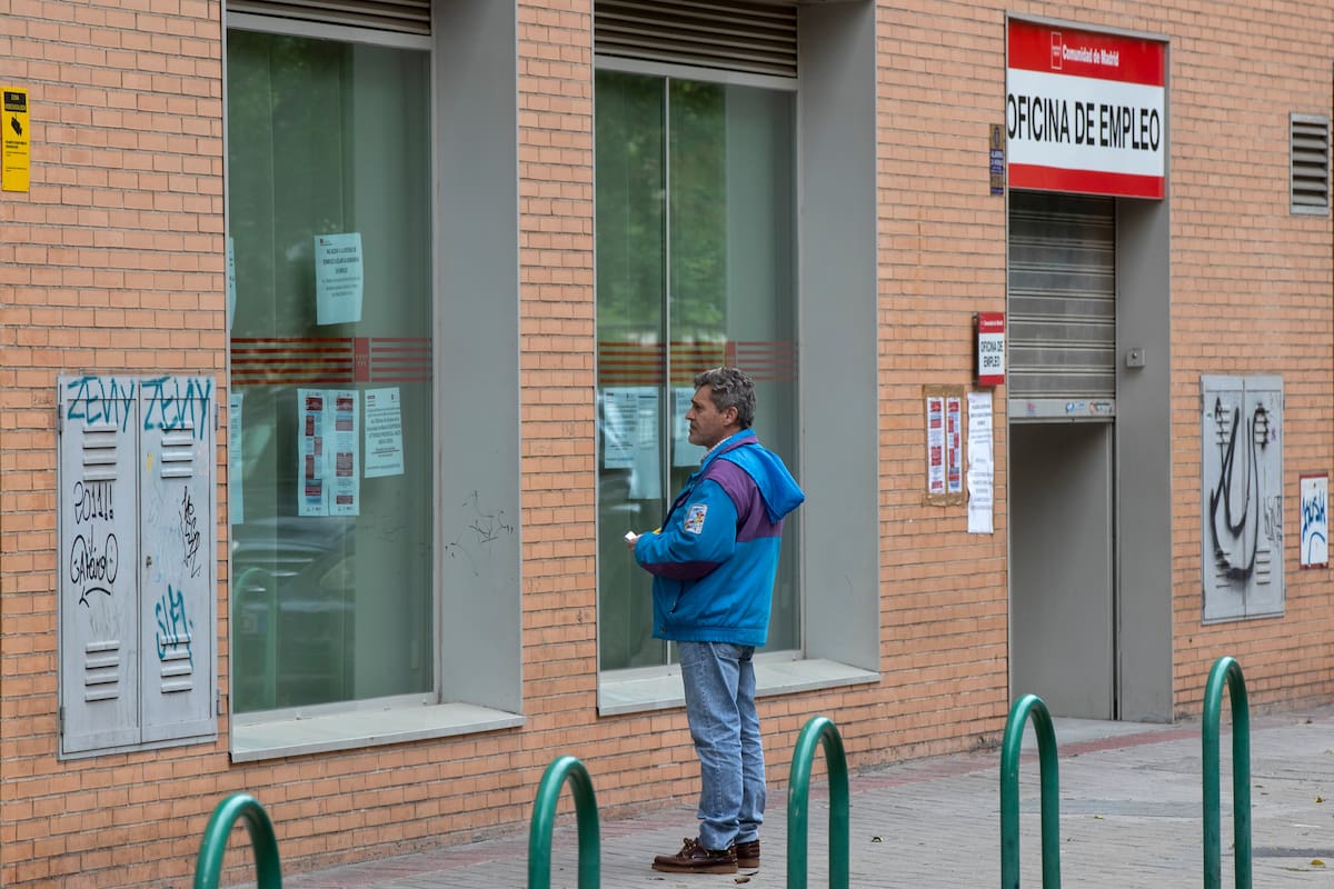 Un hombre lee los avisos en una oficina de empleo en Madrid, España, el martes 28 de abril de 2020. (AP Foto/Paul White, File)
