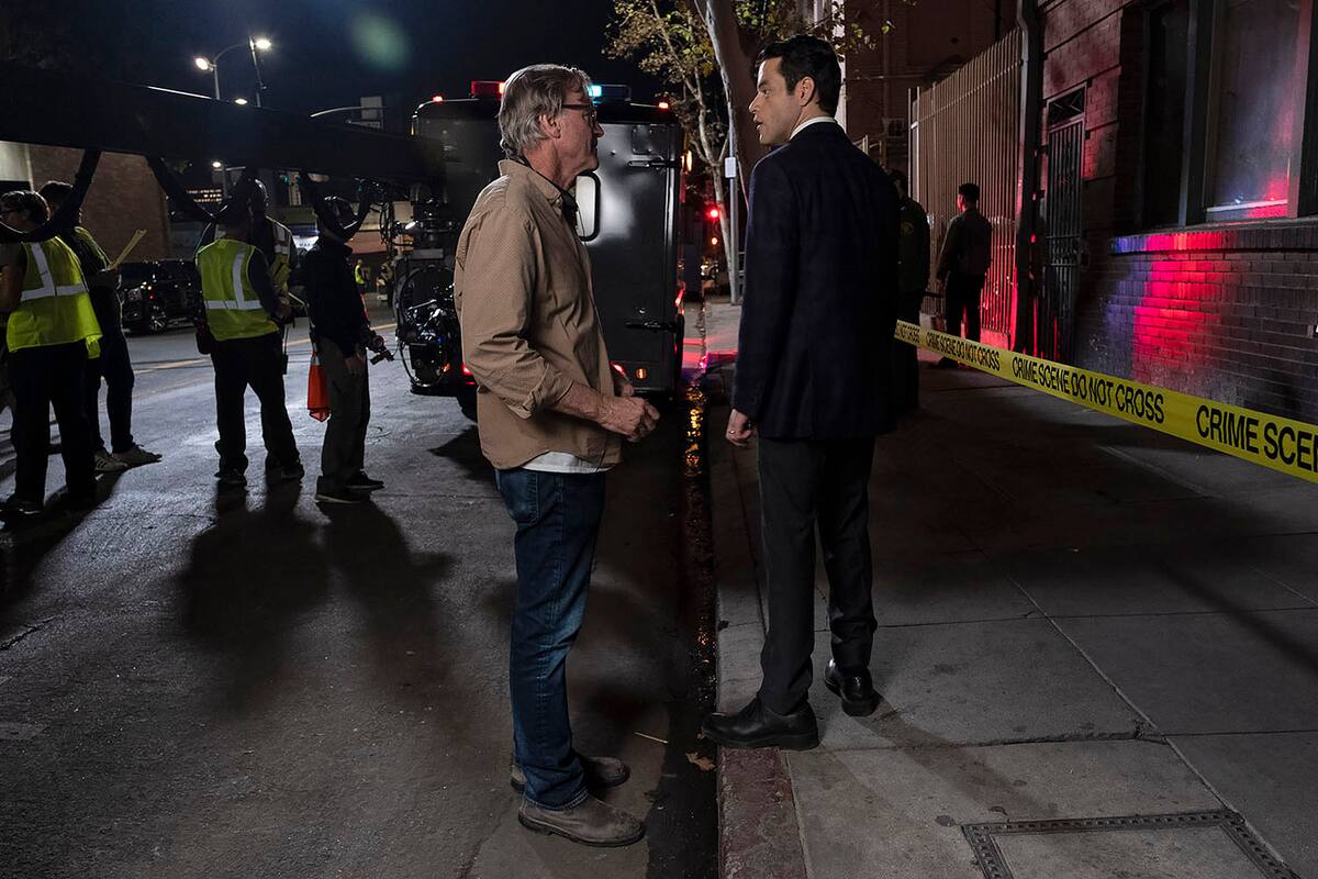 En esta imagen proporcionada por Warner Bros. Pictures el director, guionista y productor John Lee Hancock, centro, y Rami Malek en el plató de "The Little Things". (Nicola Goode/Warner Bros. Pictures via AP)