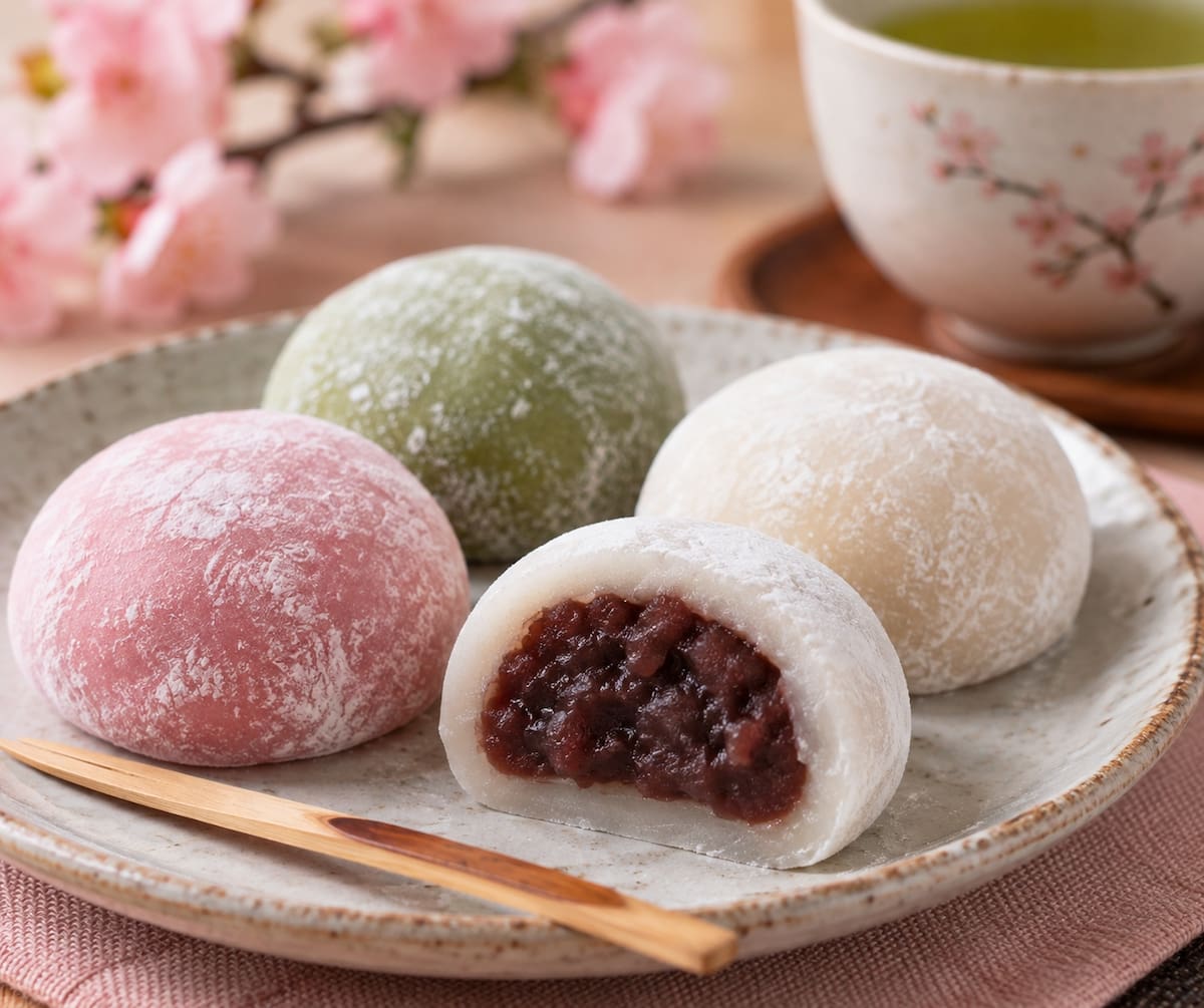 Los mochis japoneses se elaboran con arroz glutinoso y destacan por su textura suave, pegajosa y elástica; pueden llevar distintos rellenos, como pasta de frijol rojo. | Crédito: Imagen hecha con IA de ChatGPT