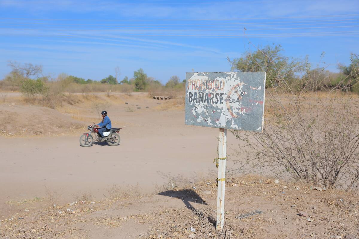 El letrero de “Prohibido bañarse” aún sigue en el cauce del río pese a que está totalmente seco. FOTO: JULIO CLARK