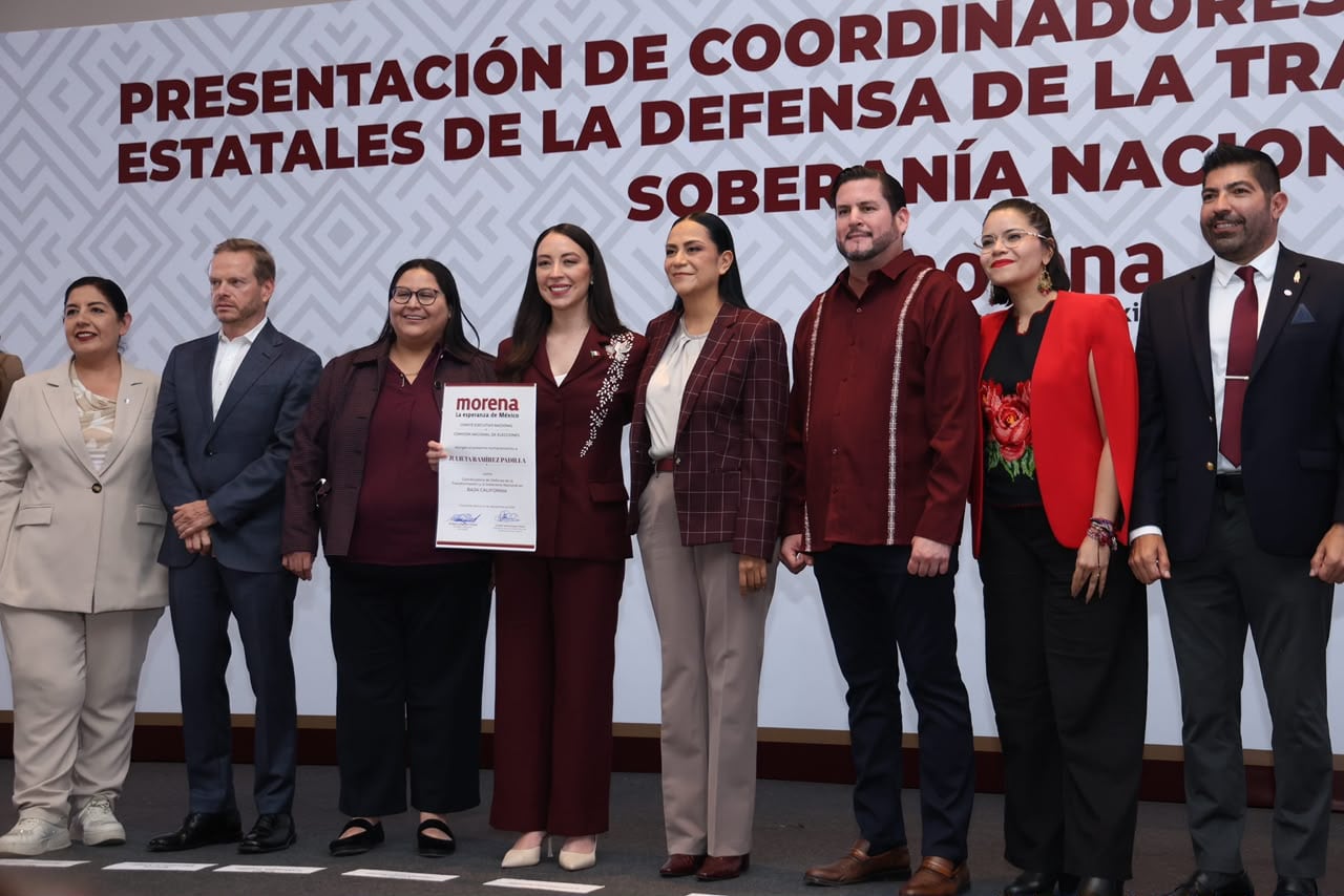 Julieta Ramírez Padilla sostiene la boleta con el resultado de la elección interna de Morena en Baja California, acompañada por los demás aspirantes al proceso de selección. Foto: Cortesía / Border Zoom