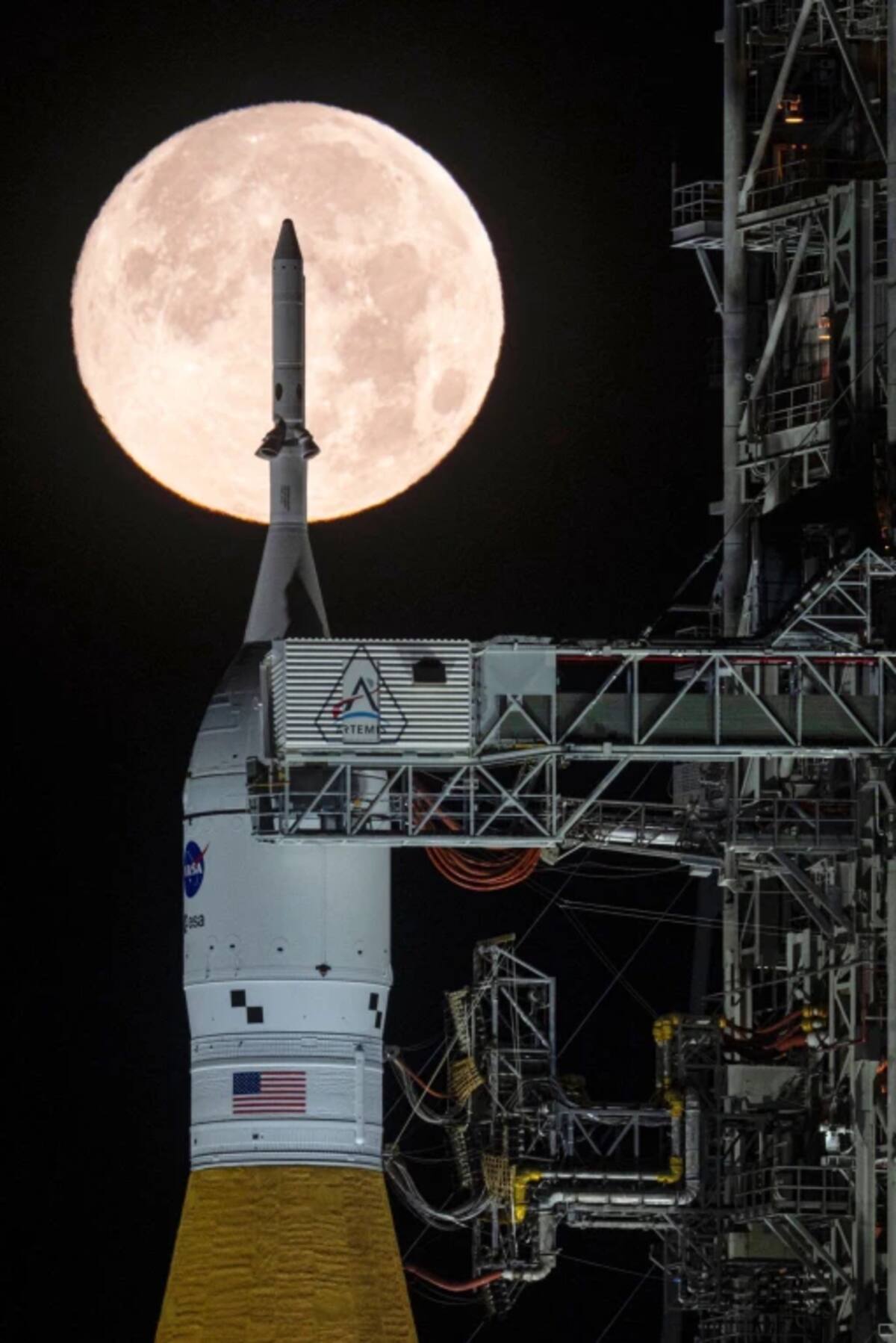 A full moon is seen shining over NASA's SLS (Space Launch System) and Orion spacecraft, atop the mobile launcher in the early hours of Sunday, Feb. 1, 2026, at NASA's Kennedy Space Center in Florida. (Sam Lott/NASA via AР)