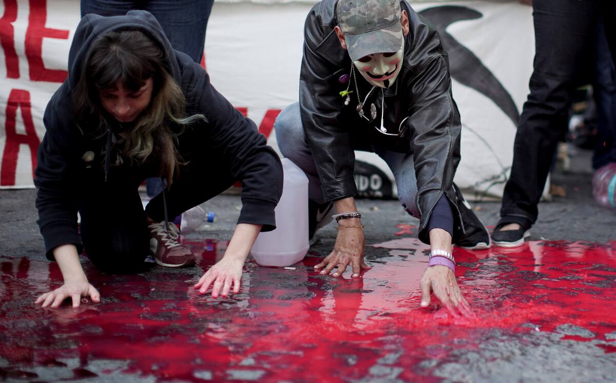 Activistas por los derechos de los animales cubren el piso con pintura roja simulando sangre animal en el exterior del Congreso, en Buenos Aires, Argentina, el 7 de agosto de 2019. Aunque no hay datos oficiales, Adrián Bifaretti, jefe del departamento de promoción interna del Instituto de Promoción de Carne Vacuna (IPCV), estima que los veganos y vegetarianos representan entre el 7 y 8% de la población. (AP Foto/Natacha Pisarenko)