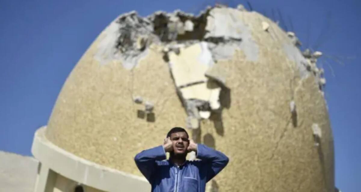 Un hombre reza frente a una mezquita destruida por los bombardeos de Israel en Gaza. / Getty Images
